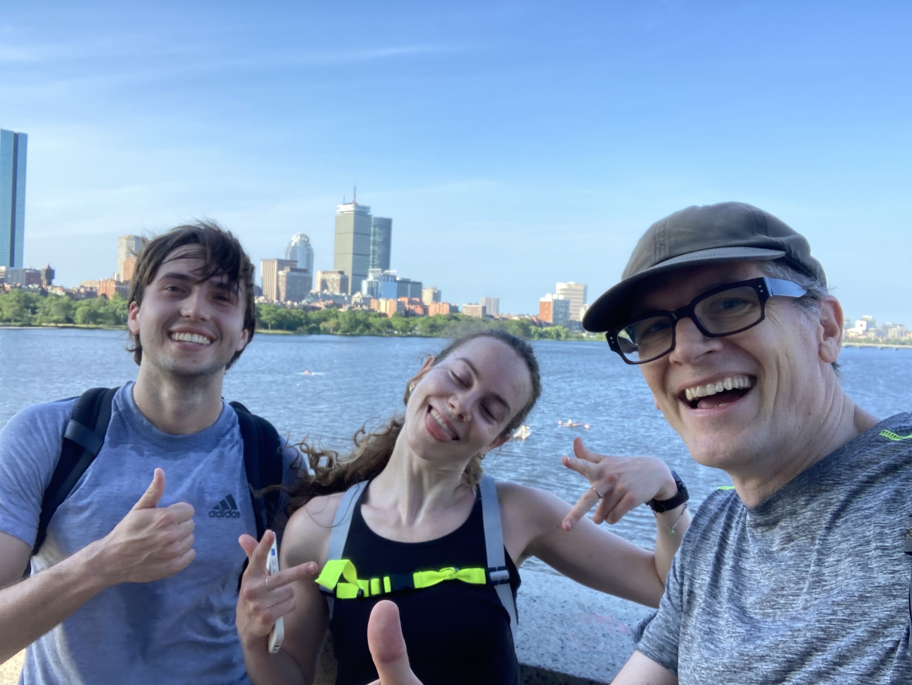 Three people looking windswept but happy, posing by the Charles River