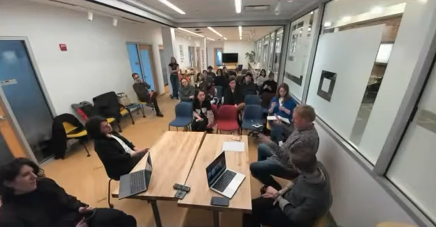 A blurry image from Zoom of the panel participants and audience